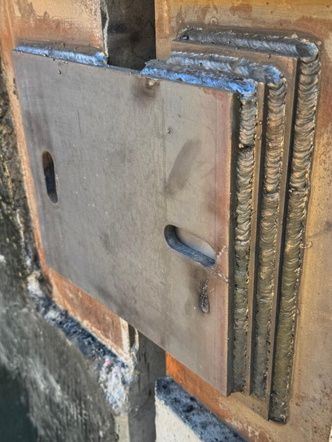 Steel connection plate at a precast panel joint